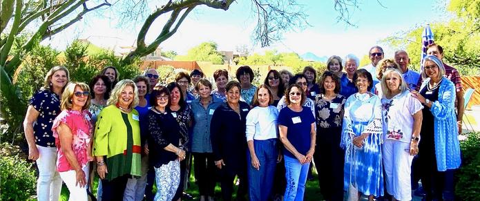 A group of women standing in front of a tree.