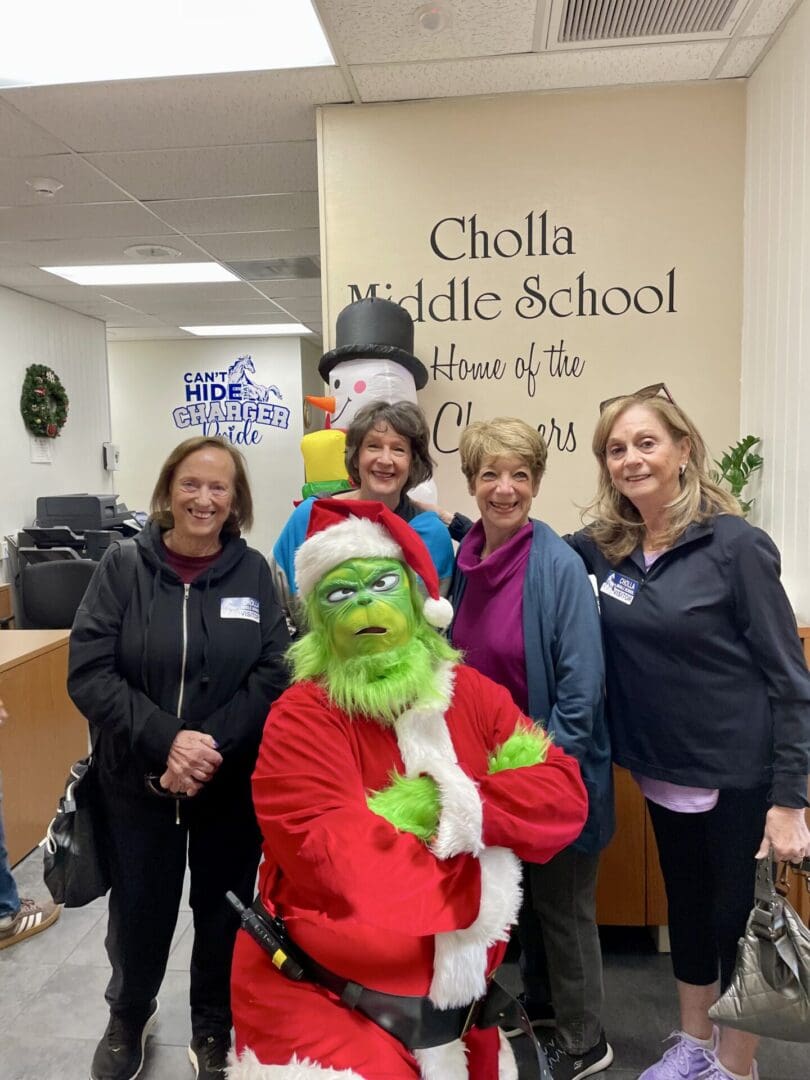 Group posing with Grinch at school event.