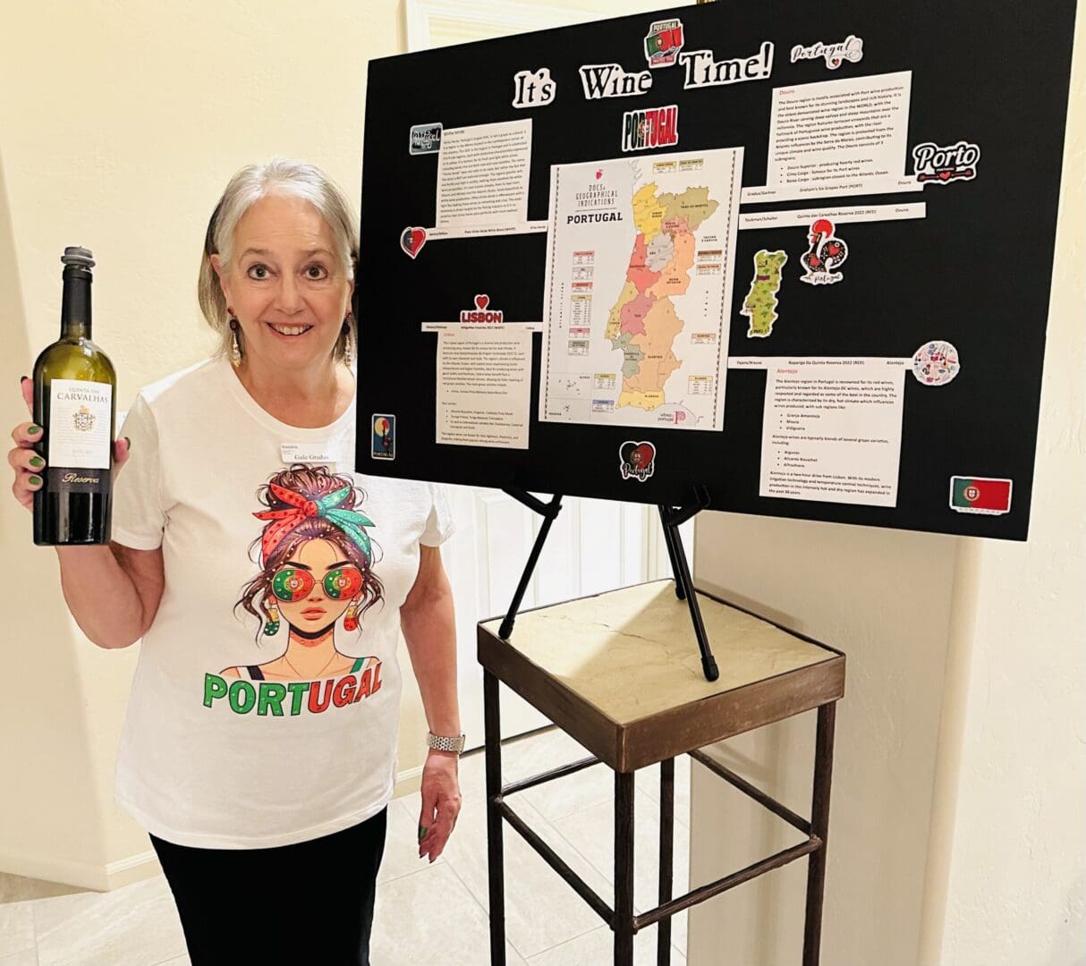 Woman holding wine bottle next to display.